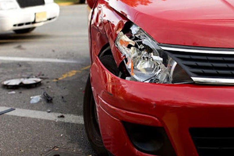 coche rojo con daños por accidente automovilístico