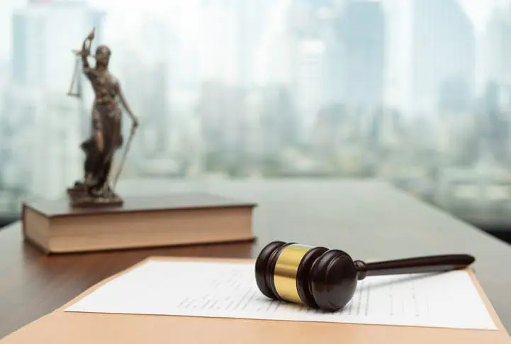 Abuso Sexual En Instituciones Religiosas 29 A Statue Holding The Scales Of Justice And A Sword Sits On A Book Alongside Of A Gavel