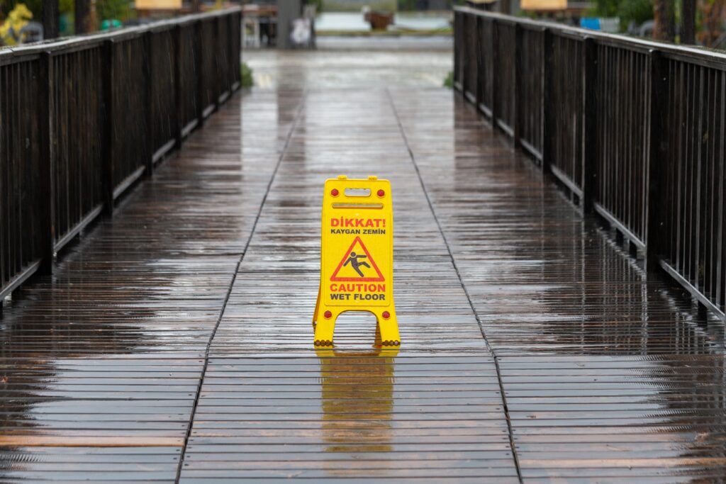 yellow caution sign on slippery outdoor walk way