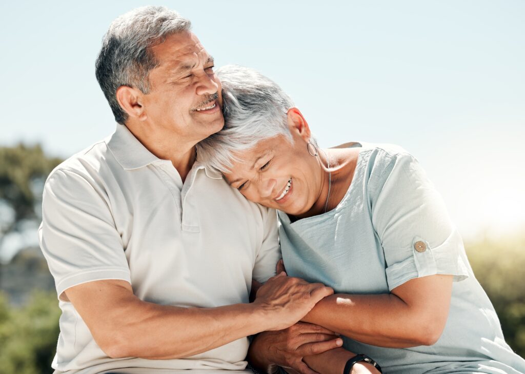 elderly couple holding each other