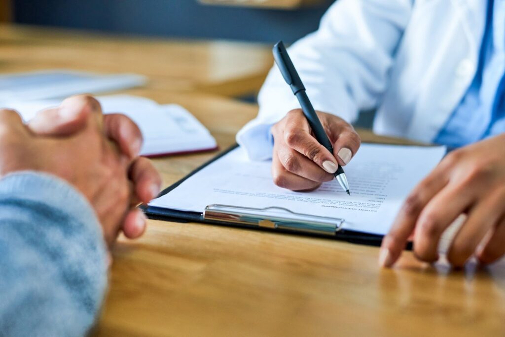 doctor writing on a medical record paper with pen