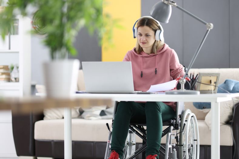 woman getting a high enough desk for her wheelchair to fit in at work