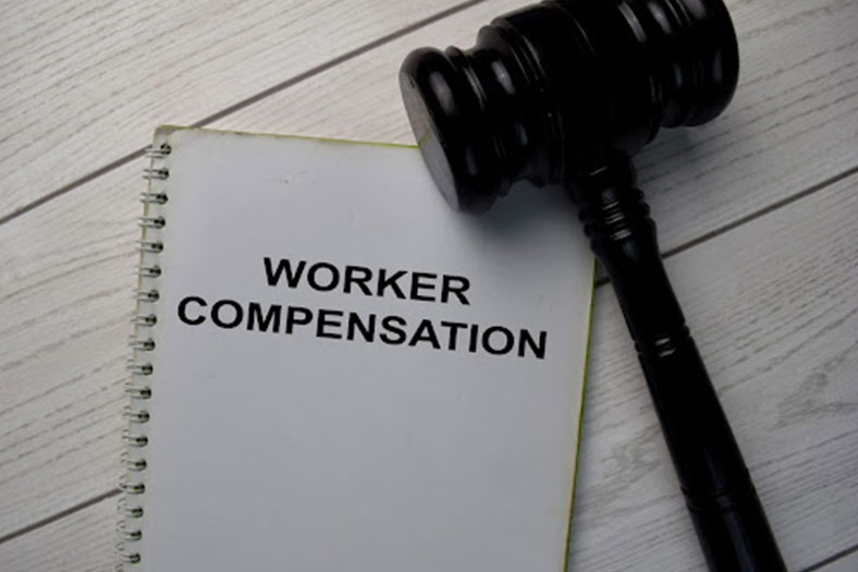 workers compensation written on a document next to gavel