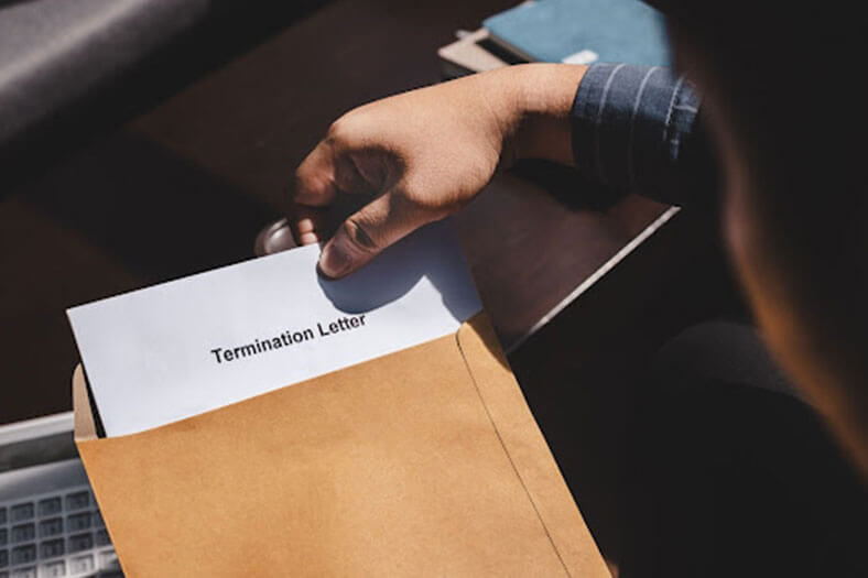 workers compensation victim taking out a termination letter from an envelope