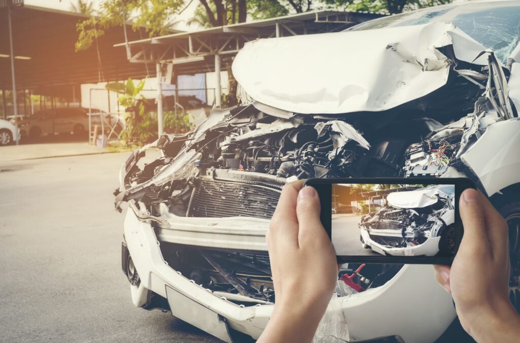 a man taking a photo of a car accident with a smart phone