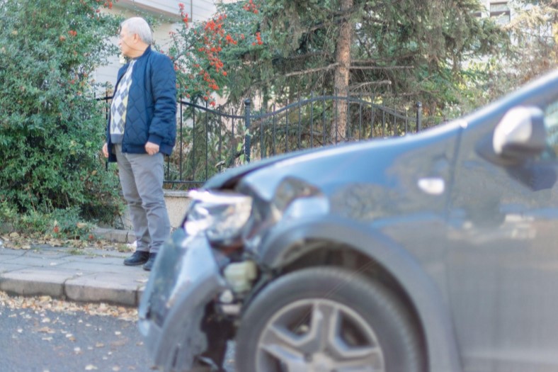 man standing outside his car after a car accident in Broomfield, Colorado