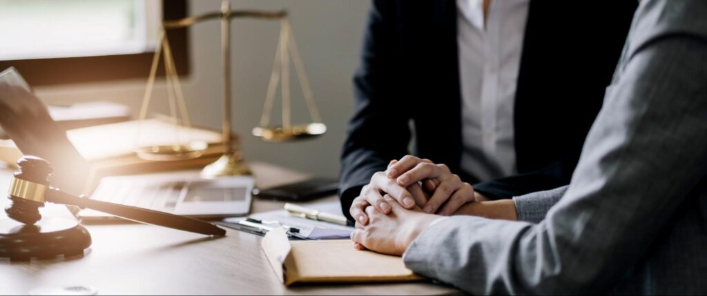 personal injury lawyer holding clients hand at a table