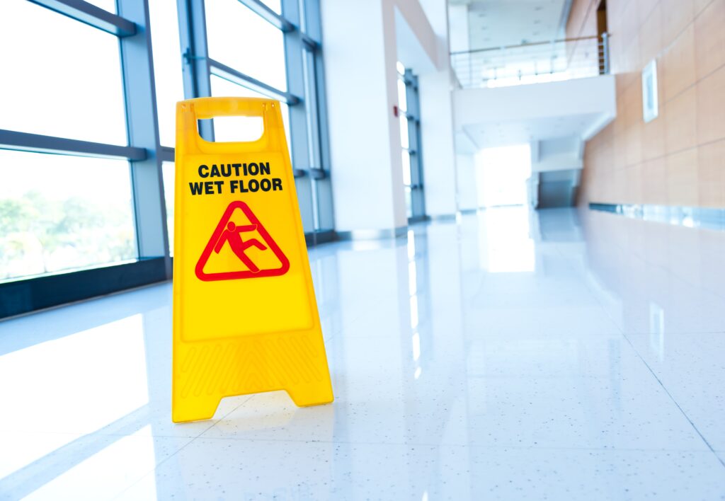 A caution wet floor sign in an empty hallway.