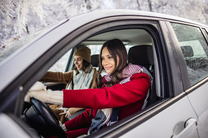two ladies driving a car in the winter