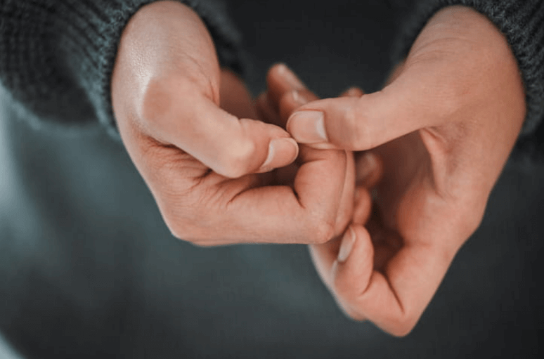 clenched hands of a sexual assault survivor in distress