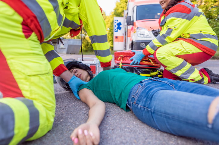 A woman with a catastrophic injury being treated by emergency personnel