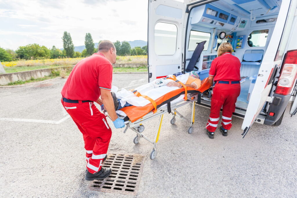 A victim with catastrophic injuries on a stretcher being loaded into an ambulance.