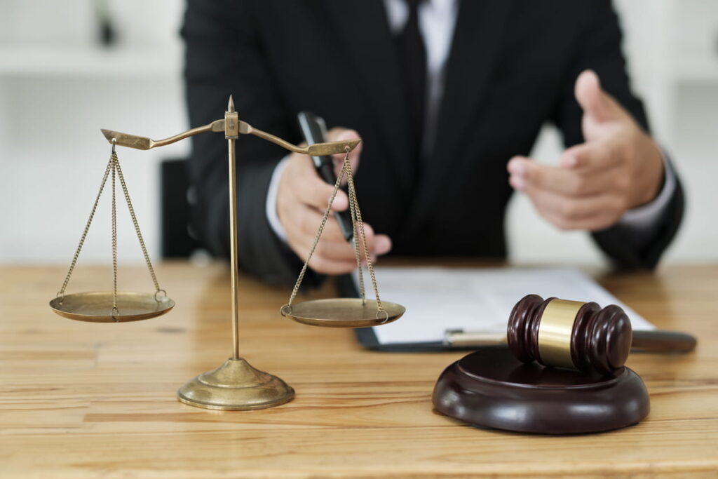 Closeup of a Englewood personal injury lawyer. On his desk is the scales of justice, a gavel, and paperwork.