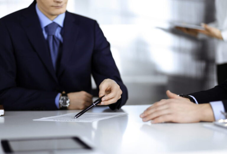 A car accident attorney sits at a table going over paperwork with their client