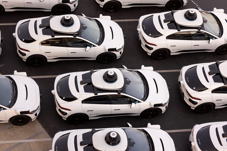 A parking lot full of Waymo vehicles.