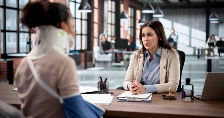 A workers' comp lawyer speaks with her injured client after a work accident.