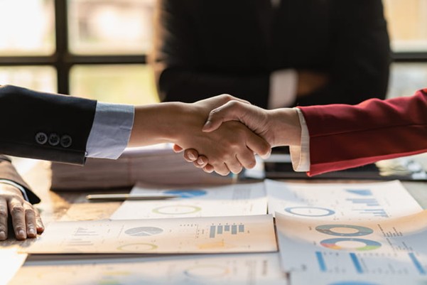 Two lawyers shake hands after a wrongful death settlement.