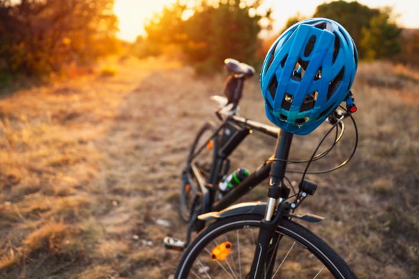 A close-up of a bicycle and cycling helmet in nature.