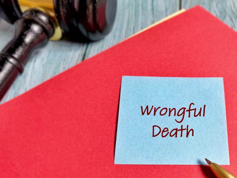 A red folder that has a blue sticky note on it that reads: "Wrongful Death." Next to it is a wooden gavel.