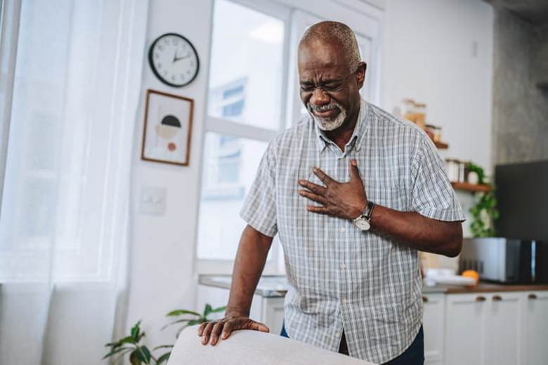 A man holds his chest in pain.